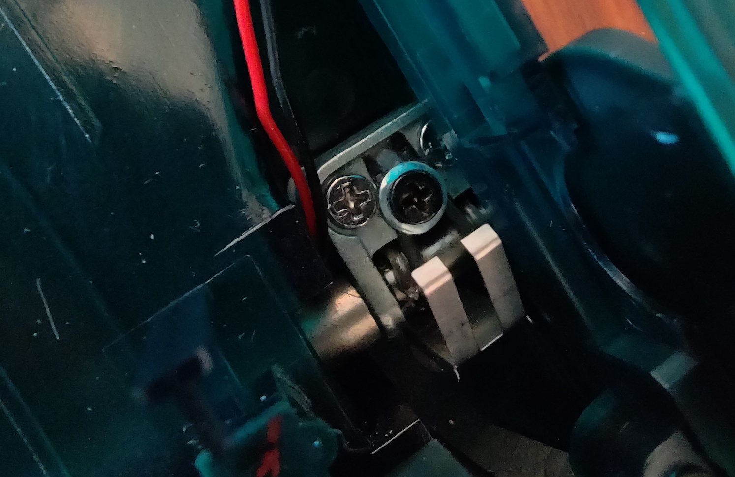 a screw with a washer under it covering a spring hinge